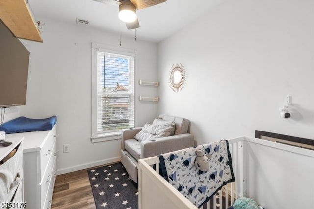 bedroom featuring baseboards, a ceiling fan, wood finished floors, and visible vents