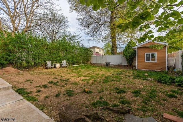 view of yard featuring fence and an outbuilding