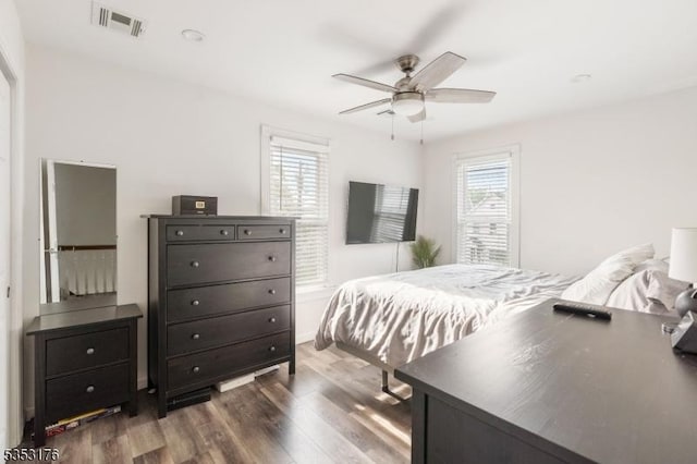 bedroom featuring ceiling fan, wood finished floors, and visible vents