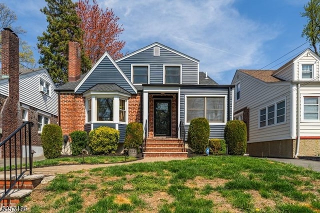 bungalow-style house with brick siding and a front yard