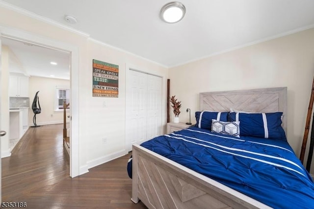 bedroom featuring baseboards, ornamental molding, a closet, and dark wood finished floors