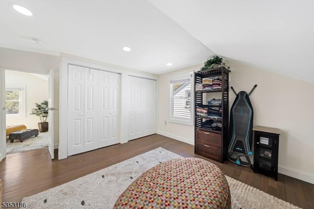 bedroom featuring vaulted ceiling, wood finished floors, baseboards, multiple closets, and recessed lighting