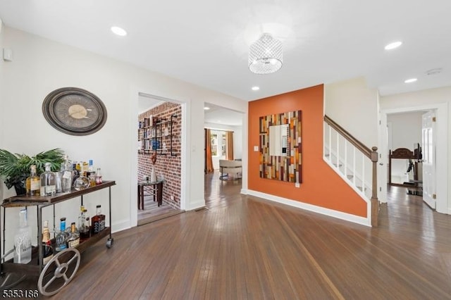 hall with baseboards, recessed lighting, wood finished floors, and stairway