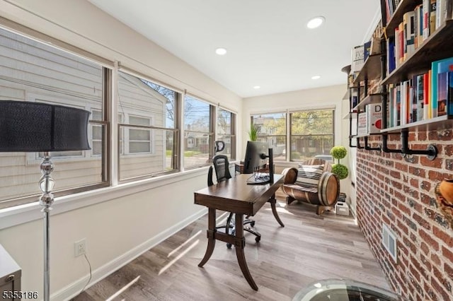 office space featuring brick wall, visible vents, wood finished floors, baseboards, and recessed lighting