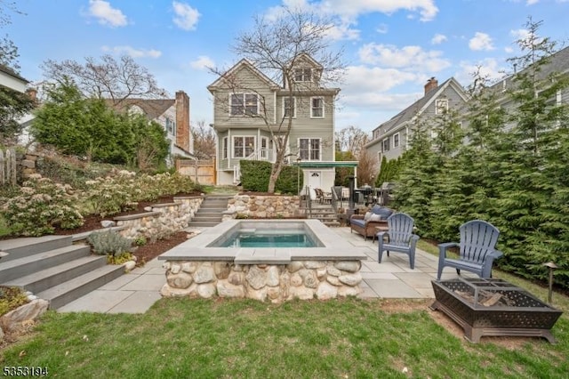 rear view of property with a fire pit, stairs, an in-ground hot tub, and a patio area
