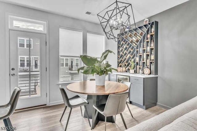 1 Sadie Cir Unit 1202, Union Twp, NJ 07083 - dining room with an inviting chandelier, light wood-style flooring, a wealth of natural light, visible vents, and a dry bar