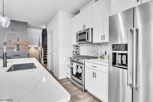 1 Sadie Cir Unit 1202, Union Twp, NJ 07083 - kitchen with a sink, stainless steel appliances, light wood-style floors, backsplash, and white cabinets