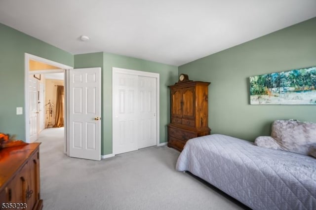 bedroom with light colored carpet, baseboards, and a closet