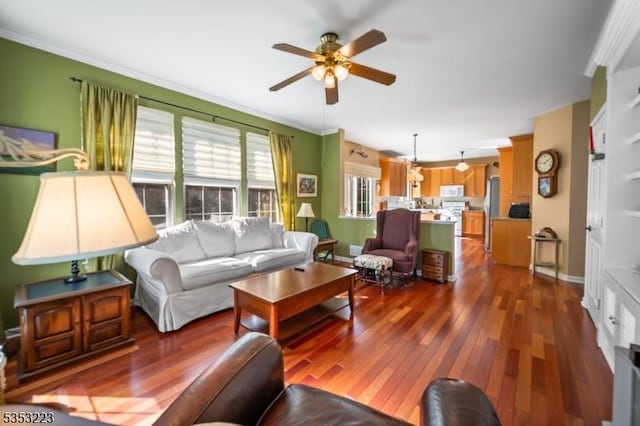 living area with crown molding, ceiling fan, and dark wood-style floors