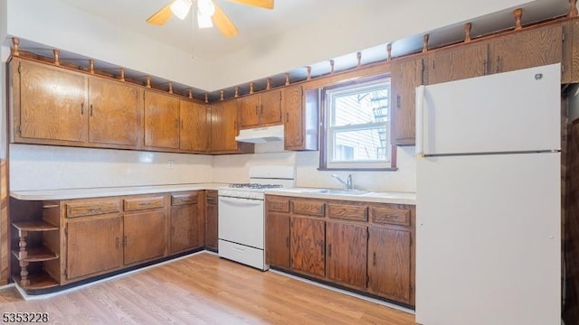kitchen featuring a sink, ceiling fan, light countertops, under cabinet range hood, and white appliances