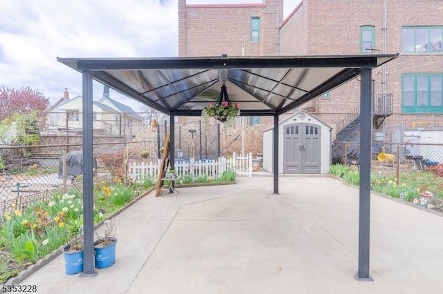 view of patio with an outbuilding, a storage shed, and fence