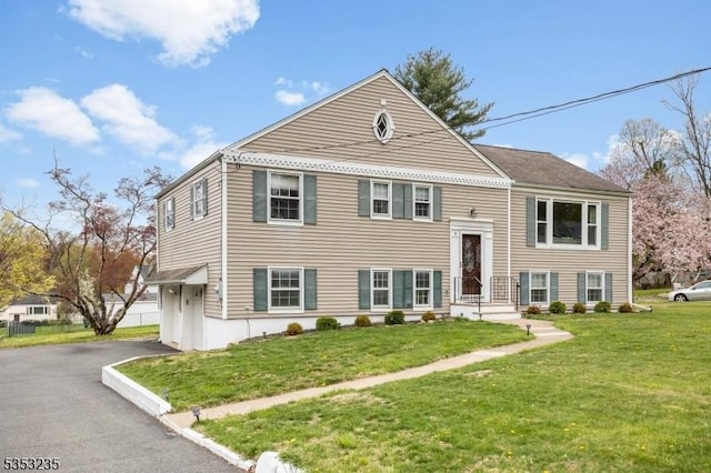 raised ranch featuring a front lawn and aphalt driveway