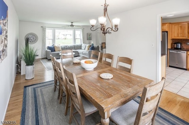 dining area featuring ceiling fan with notable chandelier and light wood-style floors