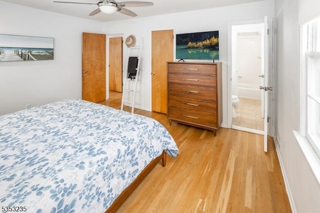 bedroom featuring ensuite bathroom, ceiling fan, and light wood-type flooring