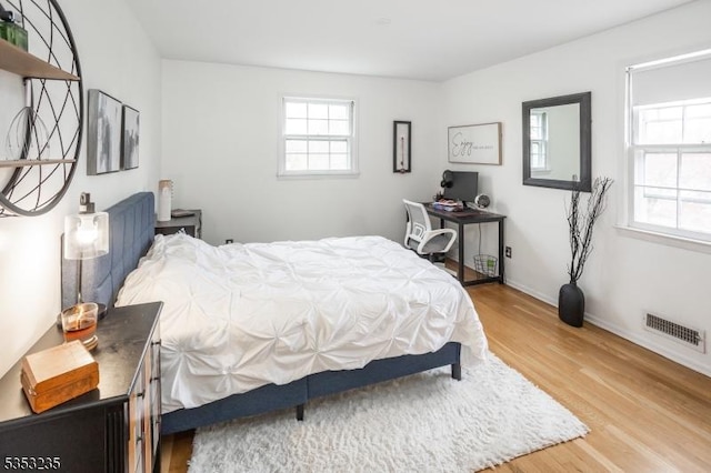 bedroom featuring visible vents, wood finished floors, and baseboards