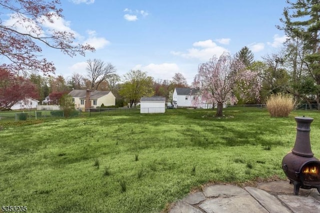 view of yard featuring fence, an outdoor structure, and a shed