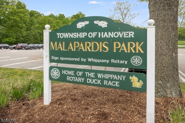 community / neighborhood sign featuring uncovered parking