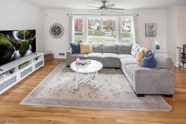 living area featuring wood finished floors, visible vents, and ceiling fan