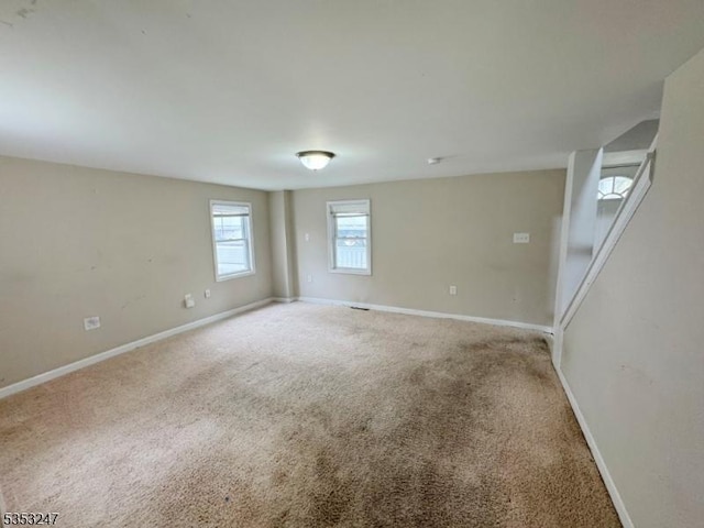 carpeted empty room featuring baseboards