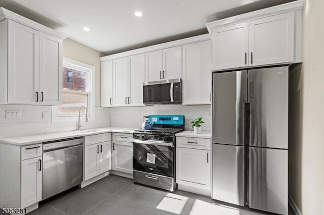 kitchen with light countertops, a sink, white cabinets, and stainless steel appliances
