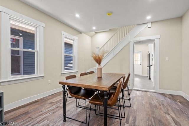 dining space with recessed lighting, baseboards, stairs, and wood finished floors