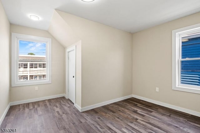 bonus room featuring dark wood-type flooring and baseboards