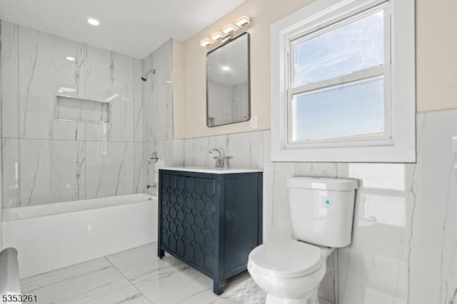 full bathroom with vanity, shower / bathtub combination, toilet, marble finish floor, and tile walls