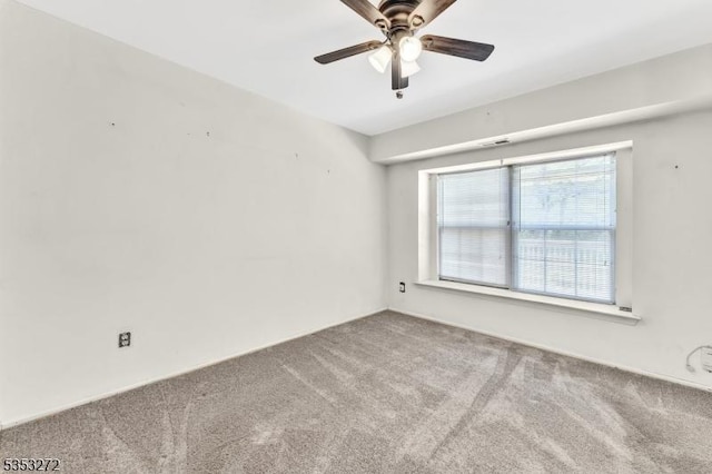 carpeted spare room with a ceiling fan
