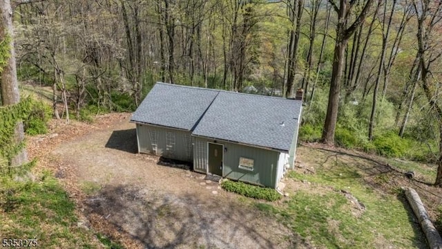 view of outdoor structure with a forest view and an outbuilding