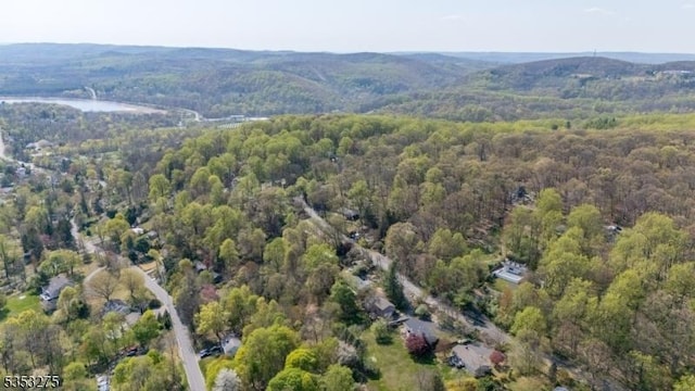 aerial view of property and surrounding area featuring a heavily wooded area