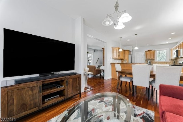 living area with dark wood finished floors and a chandelier