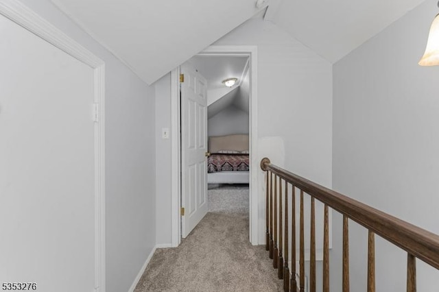 hall featuring baseboards, an upstairs landing, carpet flooring, and lofted ceiling