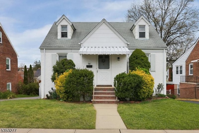 cape cod house with a shingled roof and a front lawn