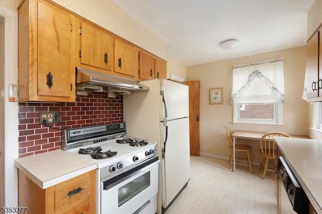 kitchen featuring white gas range, light countertops, baseboards, dishwashing machine, and under cabinet range hood