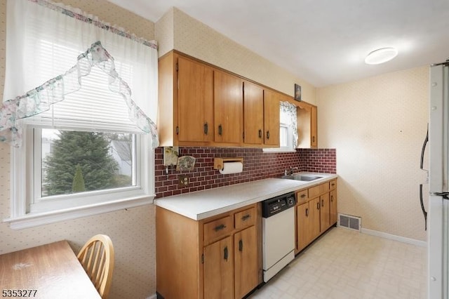 kitchen featuring visible vents, light floors, a healthy amount of sunlight, and white appliances