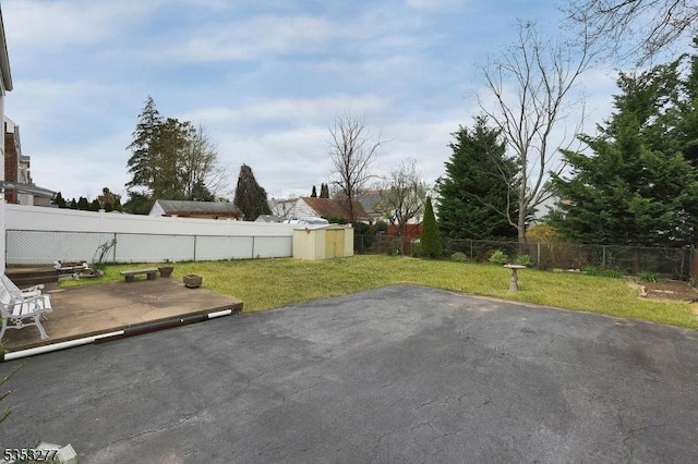 view of yard featuring a fenced backyard, a storage unit, an outdoor structure, and a patio area