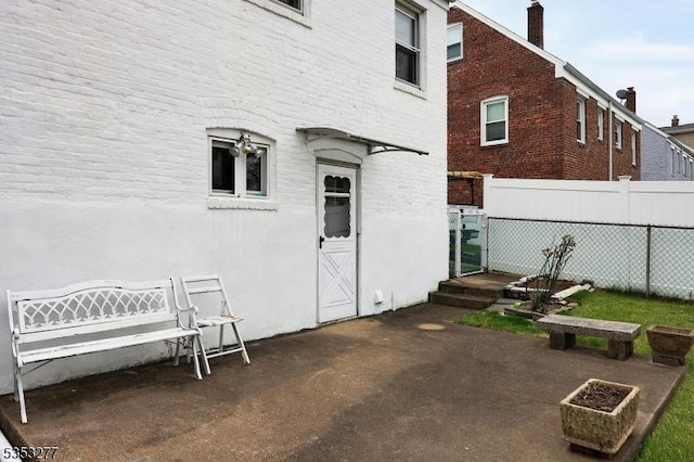 rear view of property featuring fence, a chimney, and brick siding