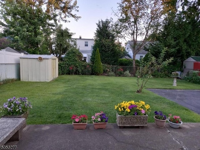 view of yard featuring a storage shed, an outdoor structure, and a fenced backyard