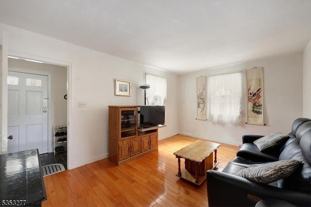 living area with baseboards and light wood finished floors