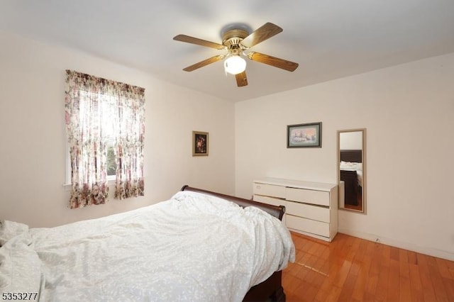 bedroom with a ceiling fan and light wood-style flooring
