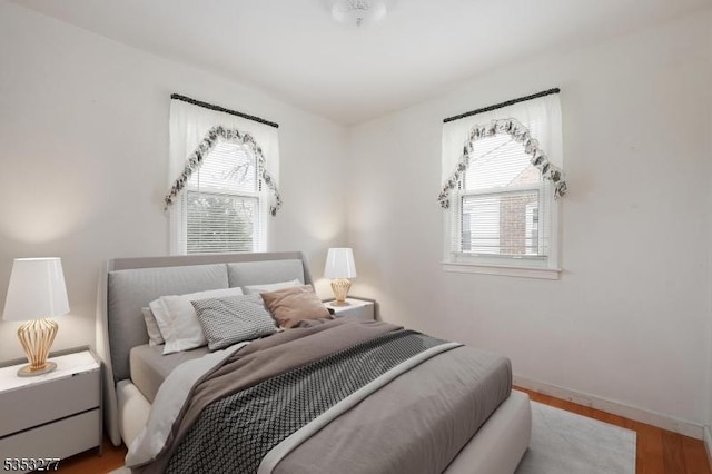 bedroom featuring baseboards and wood finished floors