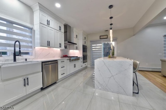 kitchen with stainless steel appliances, a baseboard heating unit, a kitchen island, backsplash, and a sink