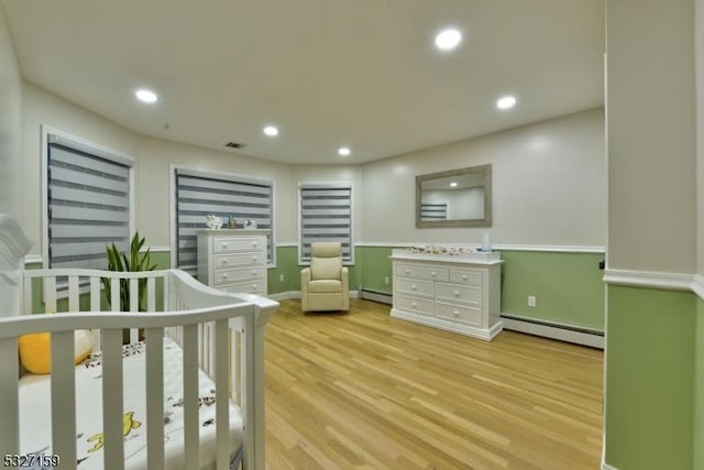 bedroom featuring baseboard heating, visible vents, light wood-style floors, and recessed lighting