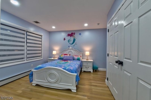 bedroom featuring visible vents, baseboard heating, baseboards, recessed lighting, and wood finished floors