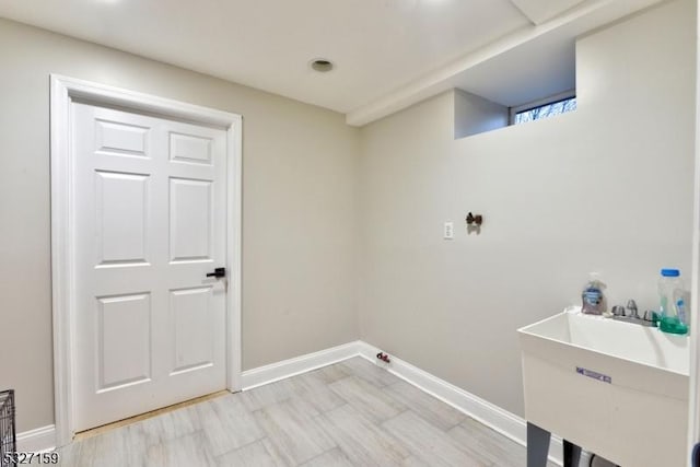 washroom with baseboards and a sink