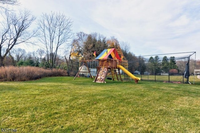 view of jungle gym featuring fence and a lawn