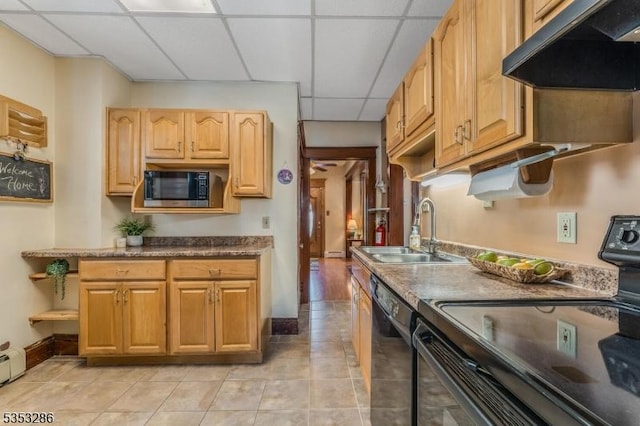 kitchen featuring a sink, light tile patterned floors, black appliances, under cabinet range hood, and a drop ceiling