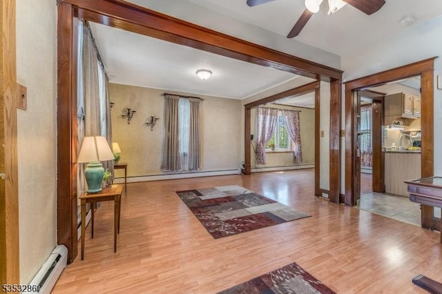 entrance foyer featuring ceiling fan, wood finished floors, and a baseboard radiator