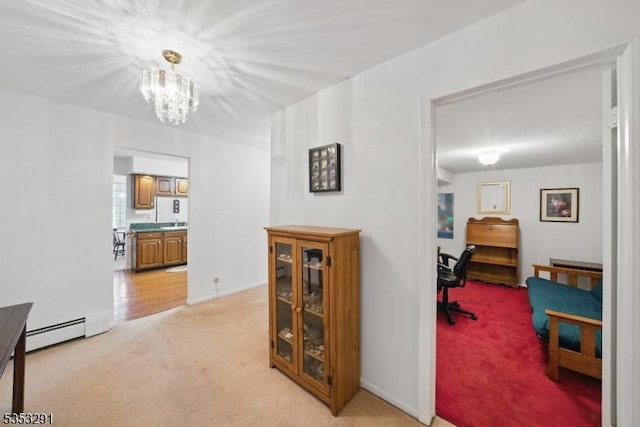 corridor featuring baseboards, baseboard heating, light carpet, and a chandelier
