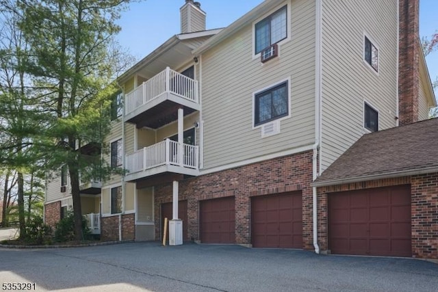 view of property with aphalt driveway and an attached garage